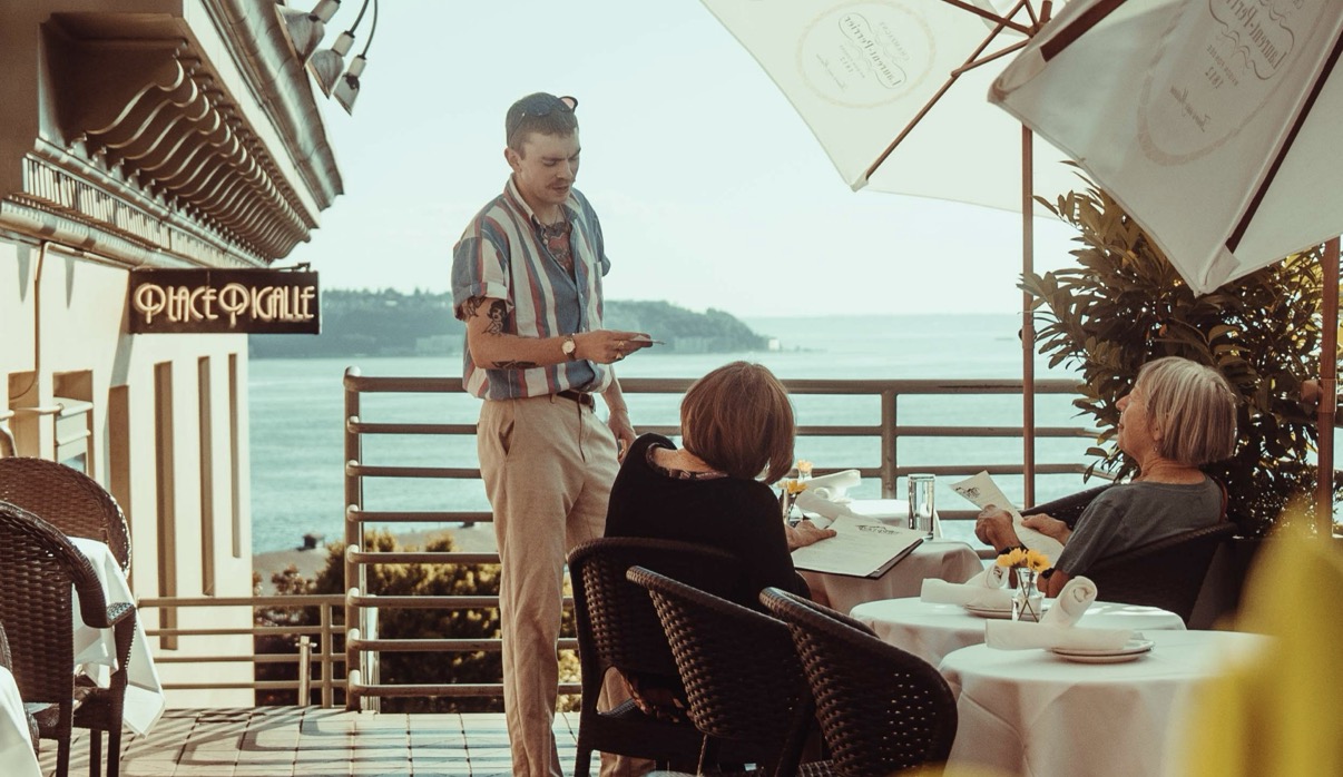 Julian taking orders on the Place Pigalle patio overlooking Puget Sound